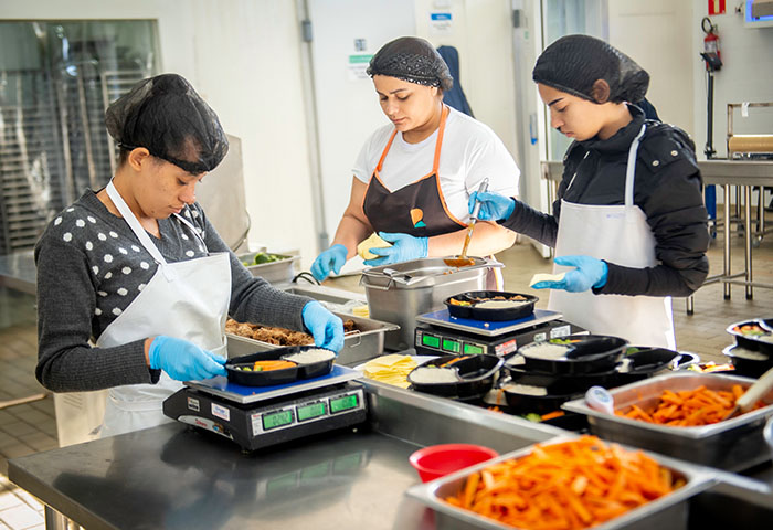 Equipe da Eat’s Good montando marmitas ultracongeladas saudáveis