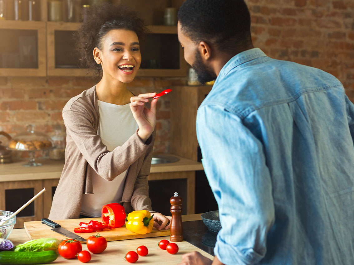 Casal preparando uma salada com base em dicas para quem não gosta de cozinhar.